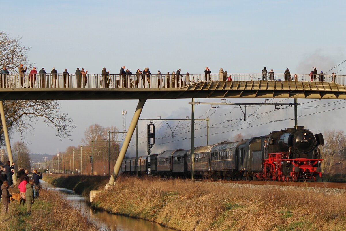 At least somebody gets interested in 23 076 with her Christmas-Express steam shuttle between Arnhem and Nijmegen on 17 December 2023, here passing under the new pedestrian/cyclists' bridge near Elst.