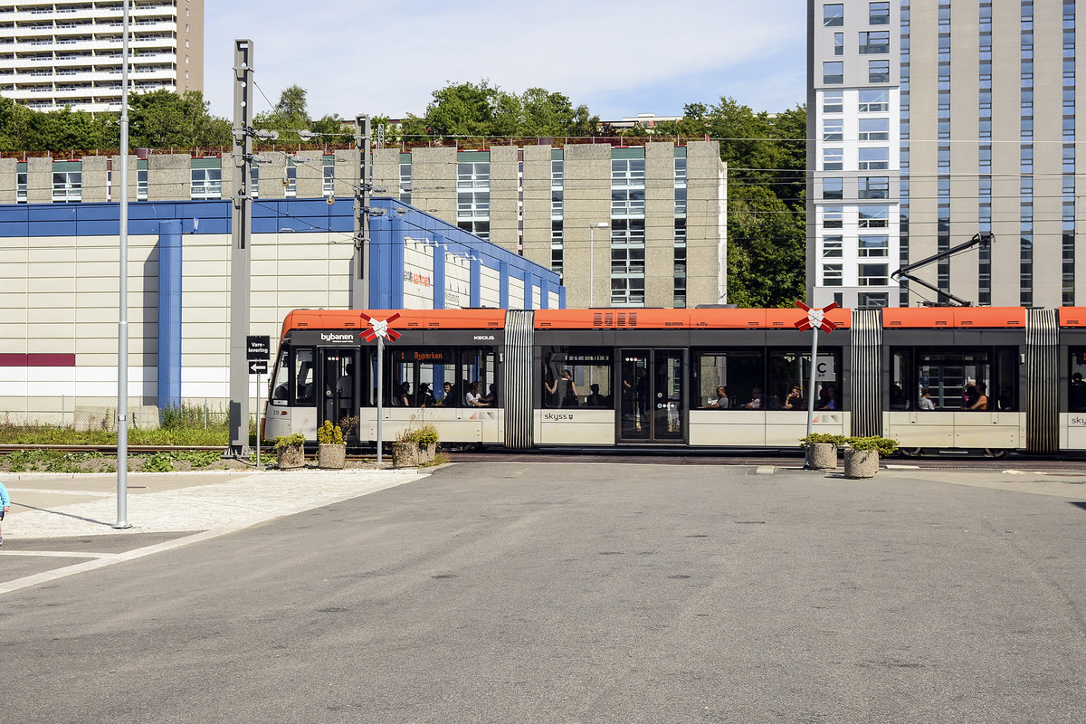 Bergen Light Rail: Tram 219 crossing Fantoftvegen in Bergen. Date: 11 July 2018.