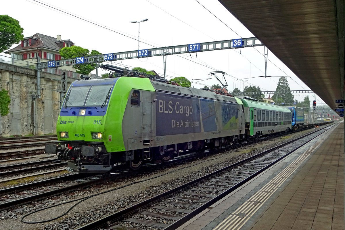 BLS 485 015 hauls an almost empty intermodal truck shuttle through a rainy Spiez on 28 May 2019.