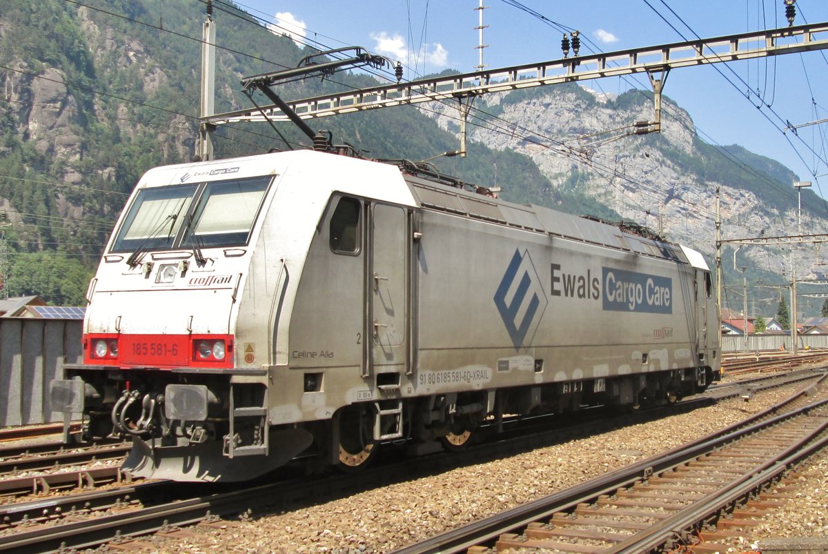 CrossRail 185 581, bearing an advertising for expedition company Ewals, runs light through Erstfeld on 6 June 2015.