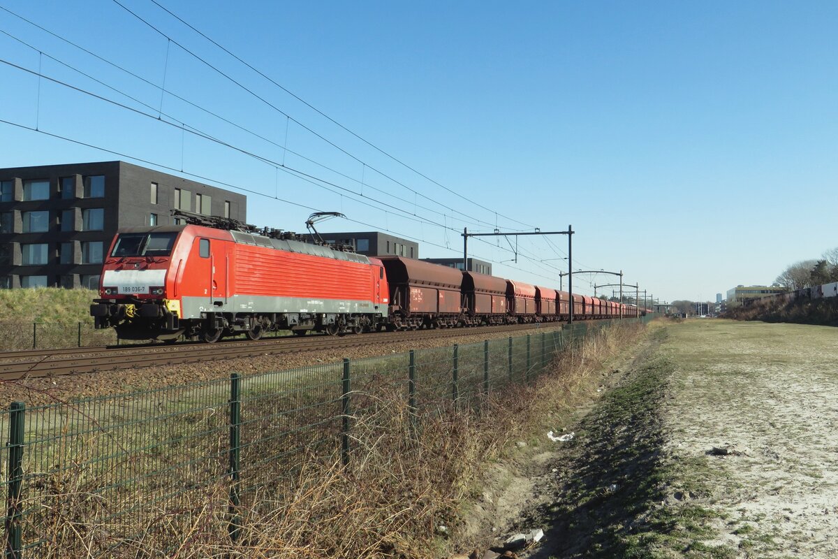 DEBC 189 036 hauls an empty ore train through Tilburg-Reeshof toward Rotterdam on 8 March 2022.