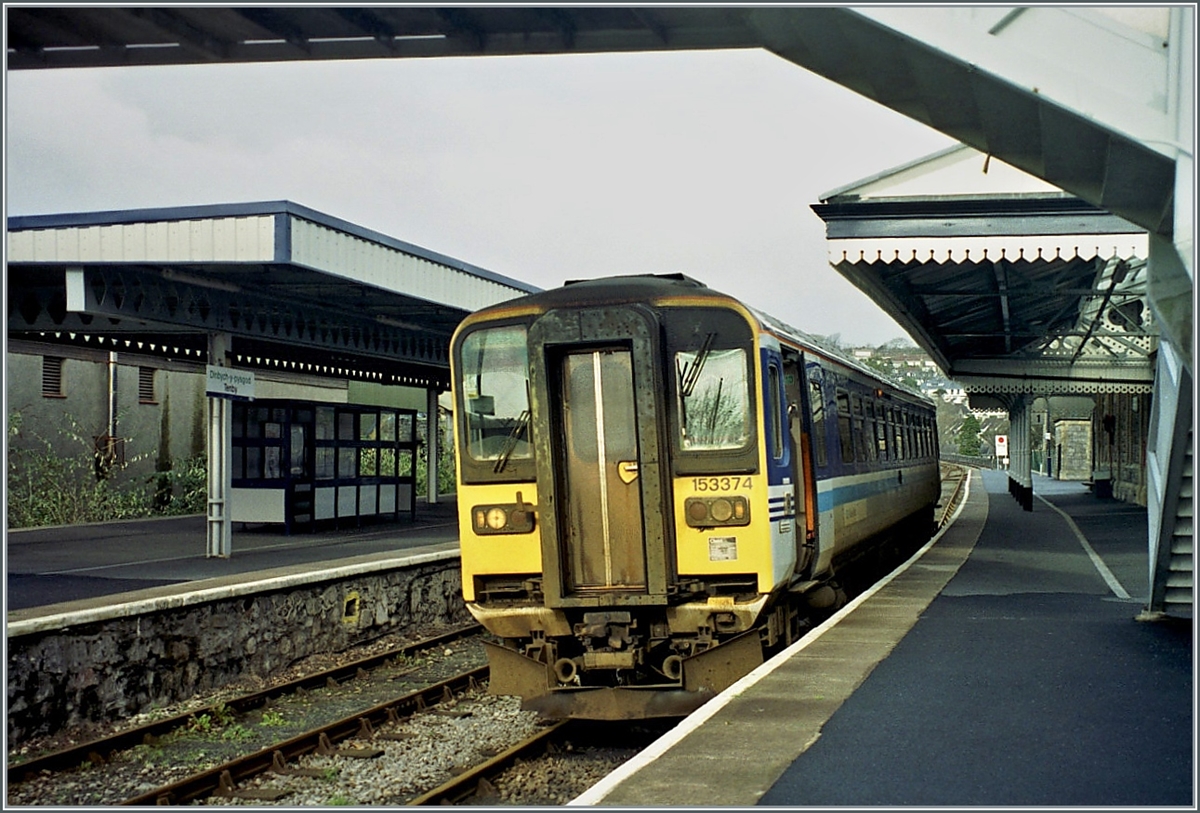 In the little Tenby / Dinbich-y - pysgod Station is stoping the Class 153 153374. 

analopicture from the november 2000