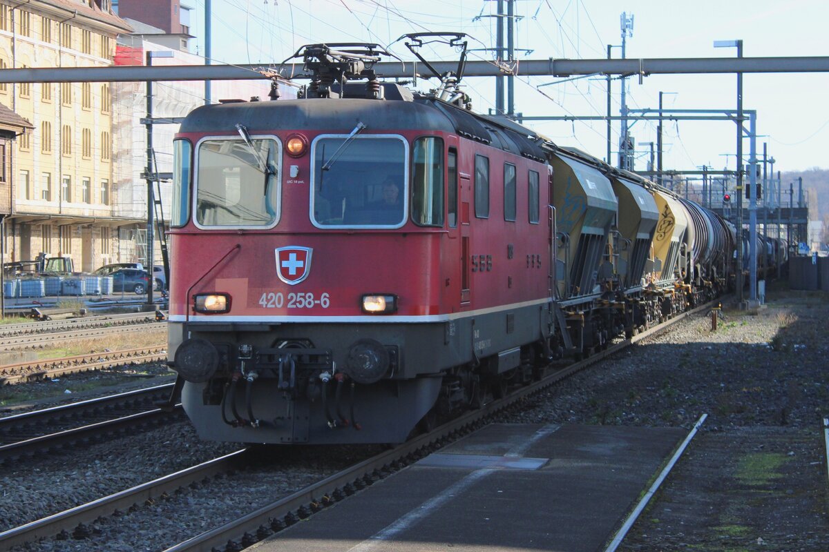 In the shadows: SBB 420 258 hauls a mixed freight through Pratteln on 13 February 2024. A famous and legal vantage point is just afew hundred yards away toward the west.