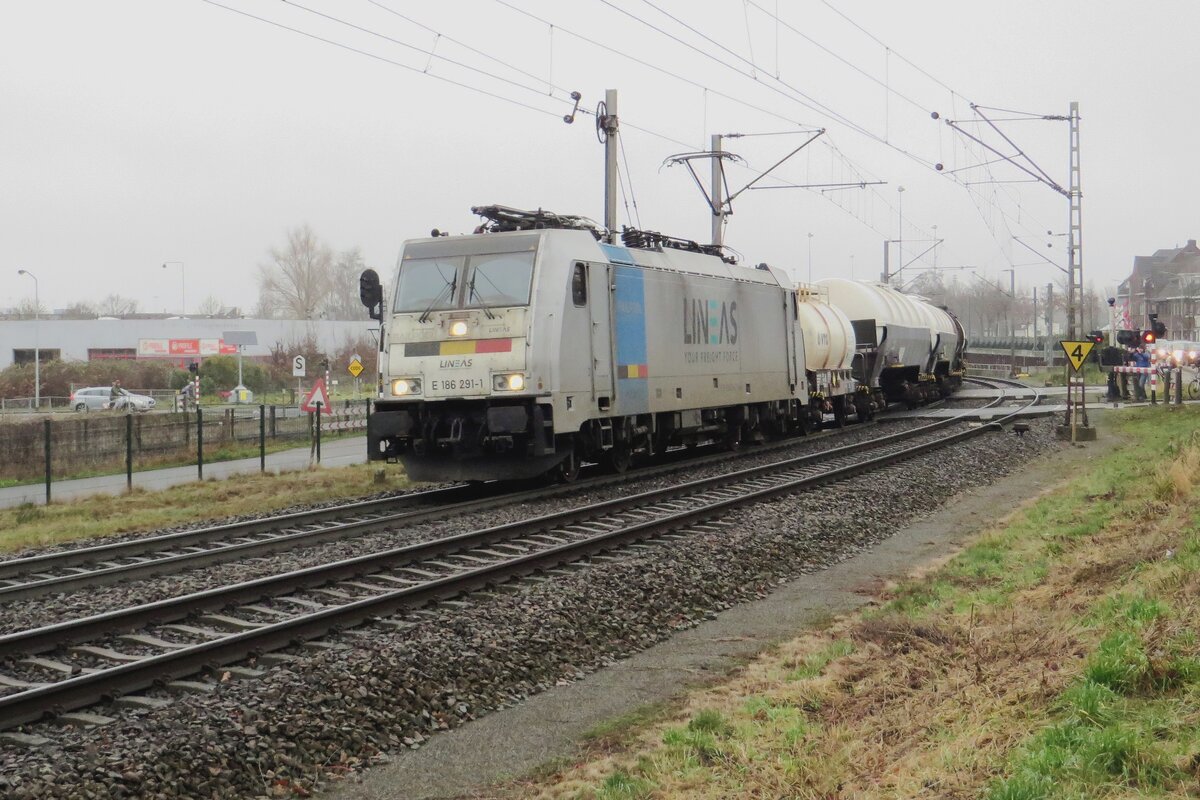 Lineas 186 291 -including Belgian flag- leaves Venlo on 17 December 2021 and has just passed   the railway crossing at Vierpaardjes -notorious (with the car drivers) and famous (for the railway photoghraphers)- into Germany.