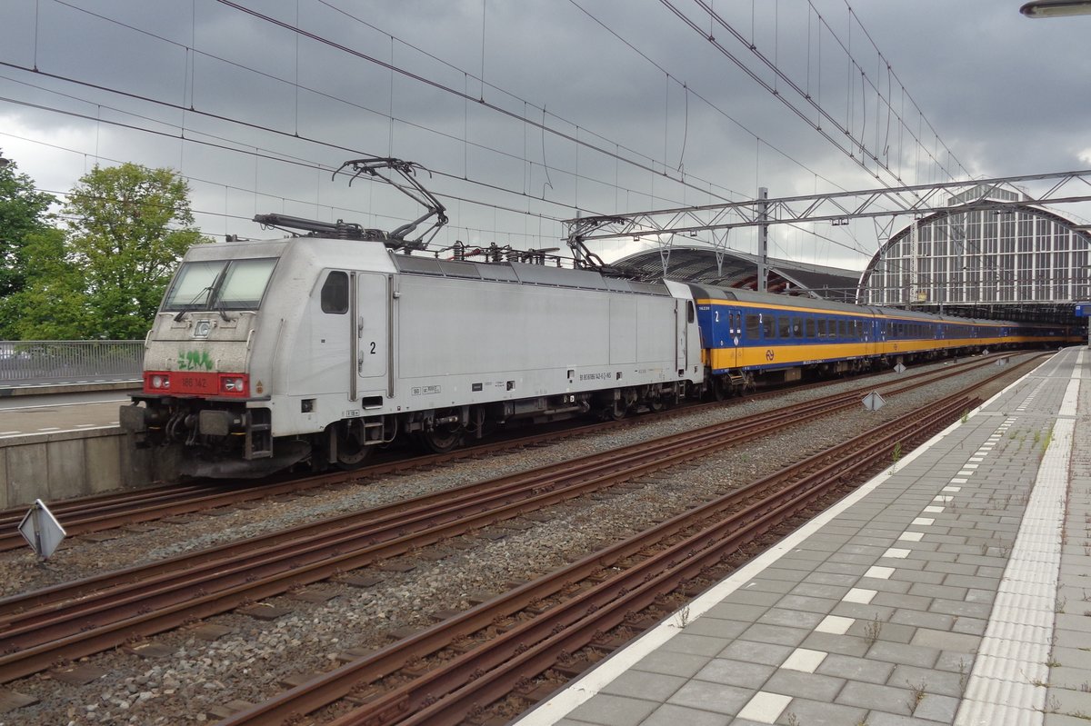 Macquarie 186 142 stands in front of an NS IC-Direct at Amsterdam Centraal on 9 July 2018.