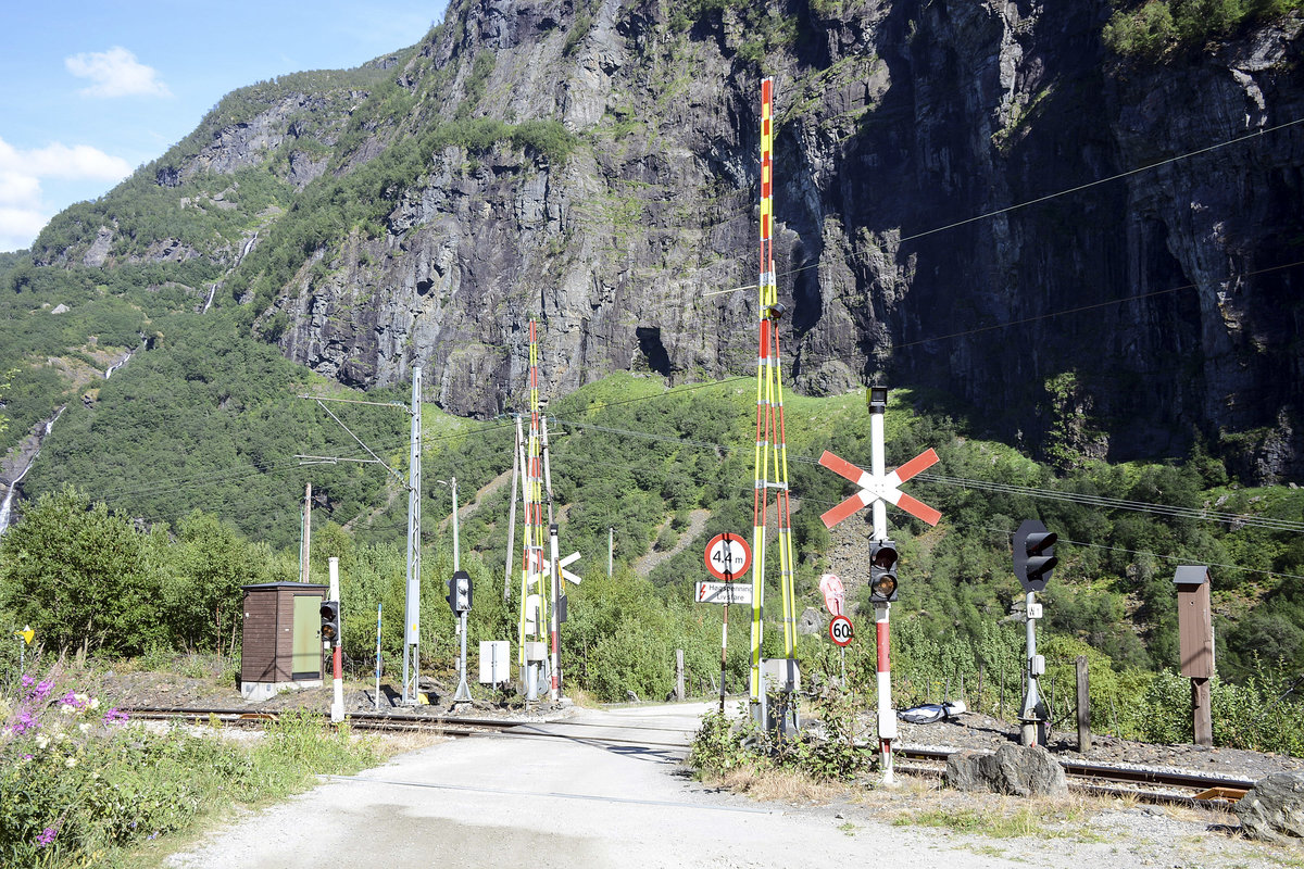 Most crossings in Europe and around the world are marked by some form of saltire (Saint Andrews Cross) to warn road users about a level crossing and/or about a level crossing with no barriers whatsoever. This cross is on a level crossing on the Flåm Railway line in Norway.
Date: 13 July 2018.