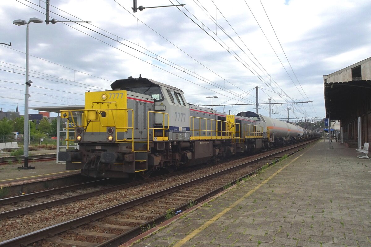 NMBS 7777 hauls a sister loco and a tank train through Lier on 14 July 2022.