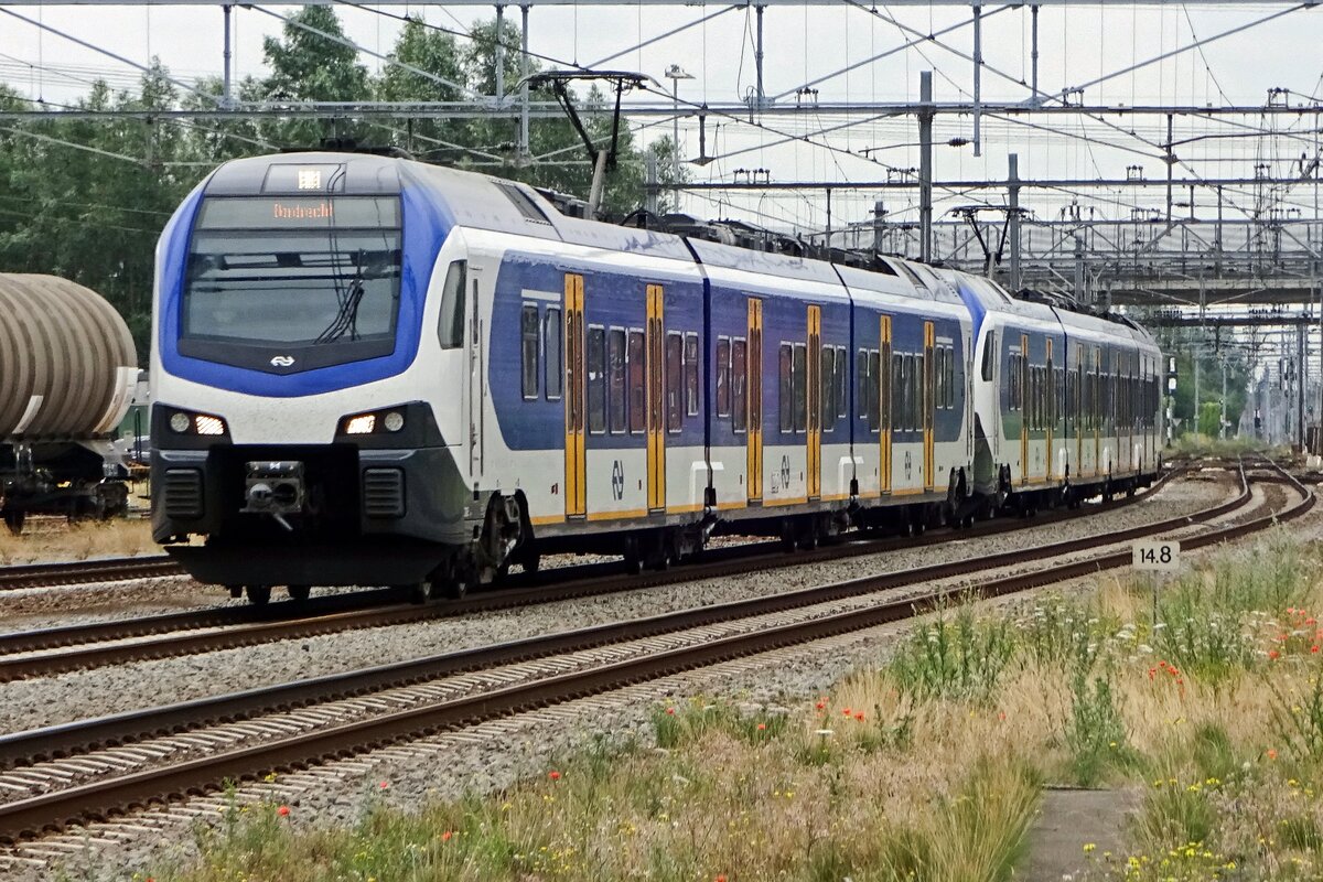 On 19 July 2019 NS 2216 is about to call at Lage Zwaluwe and gets photographed from behind the closed gates of an intra-station railway crossing.