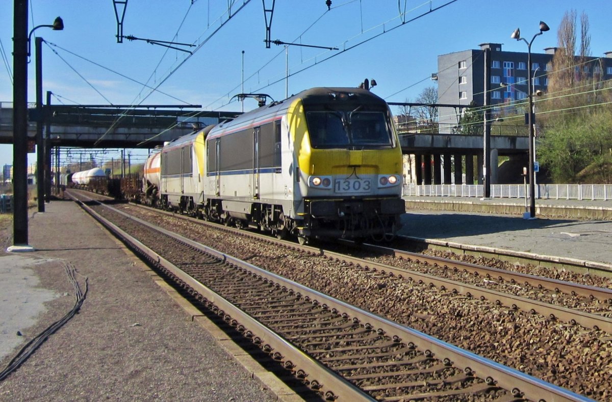 On 23 August 2013 NMBS 1303 hauls a mixed freight through Antwerpen-Noorderdokken toward the massive port area.