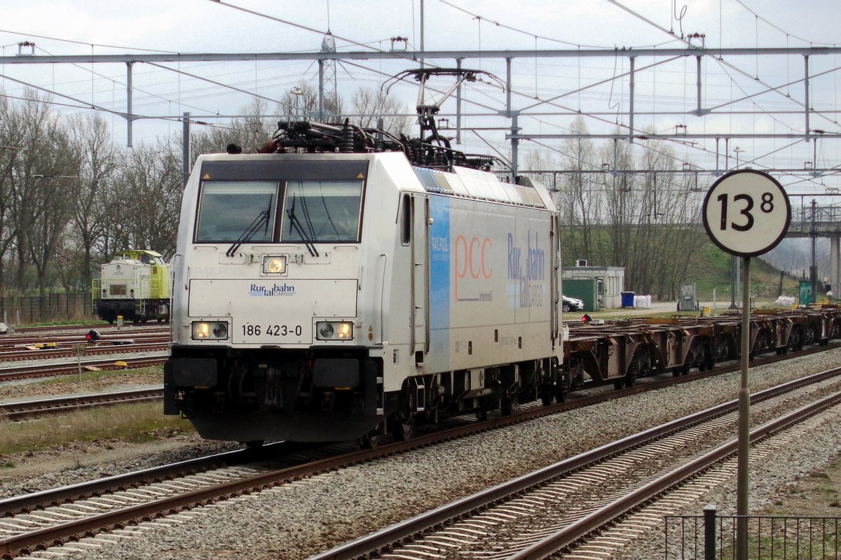On 27 March 2019 RTB 186 423 hauls an almost empty rake of container wagons through Lage Zwaluwe.