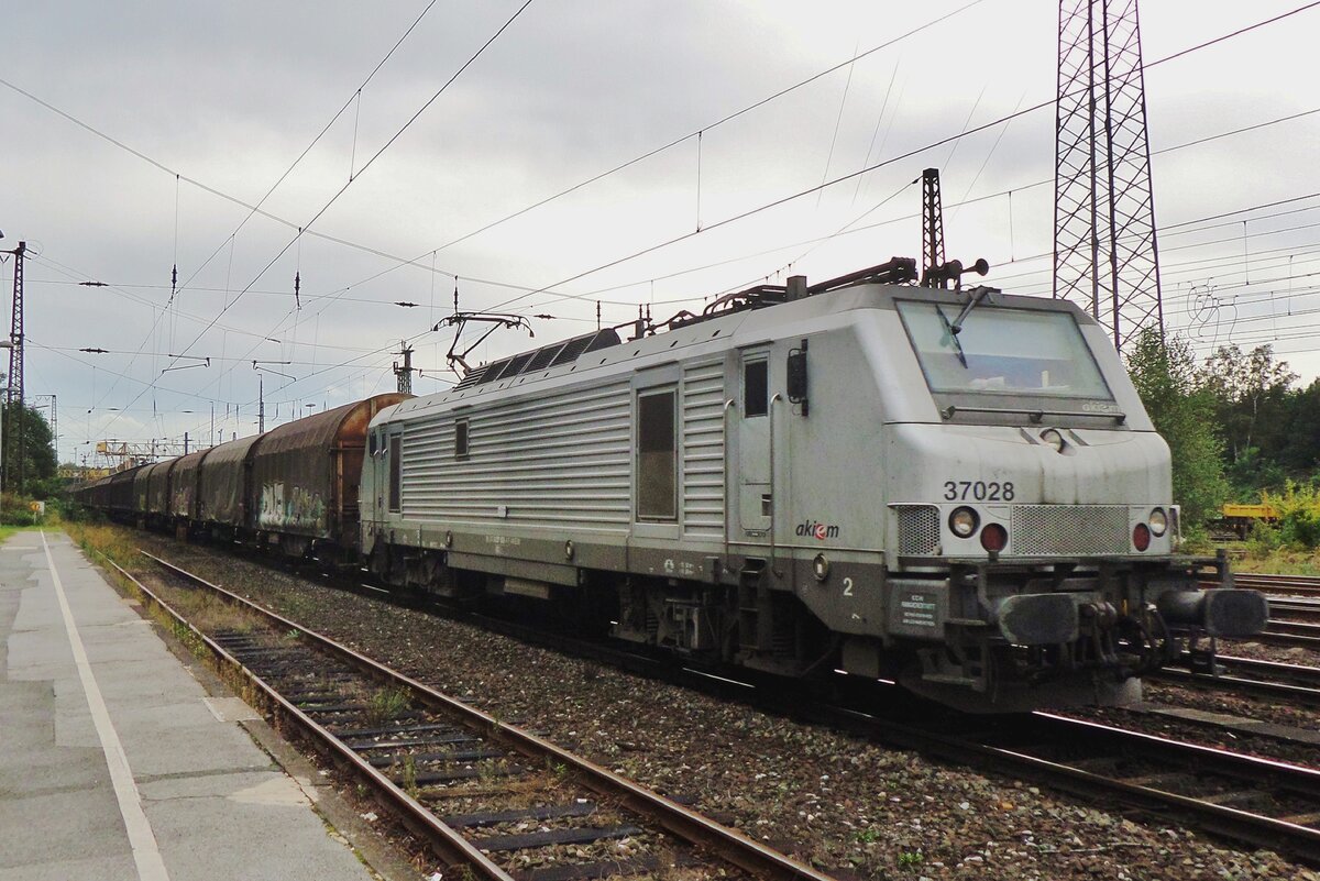 On a grey 16 September 2016 Akiem 37028 hauls a steel train through Duisburg-Entenfang.