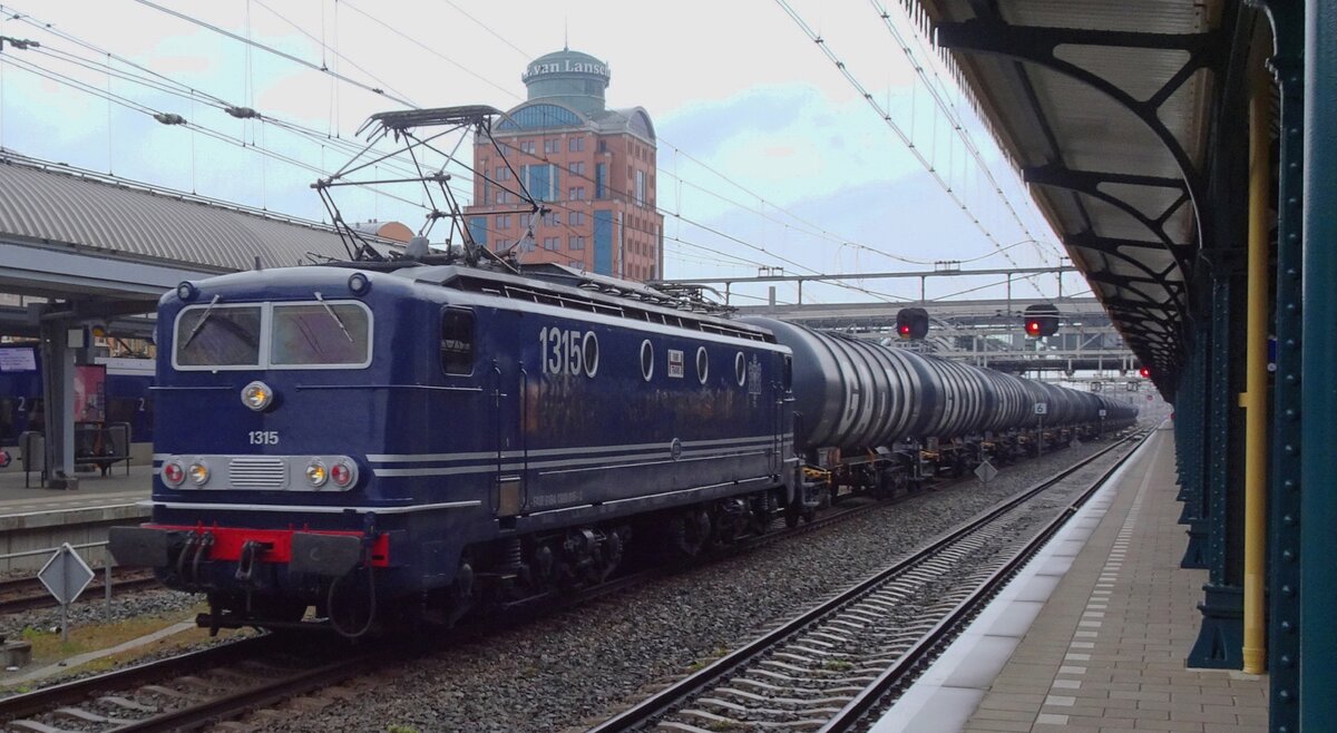 On a grey afternoon of 13 April 2022 FairTrains 1315 (in 1950s colours, but with the 1990s modifief head lights) hauls a tank train through s'-Hertogenbosch toward Eindhoven. 