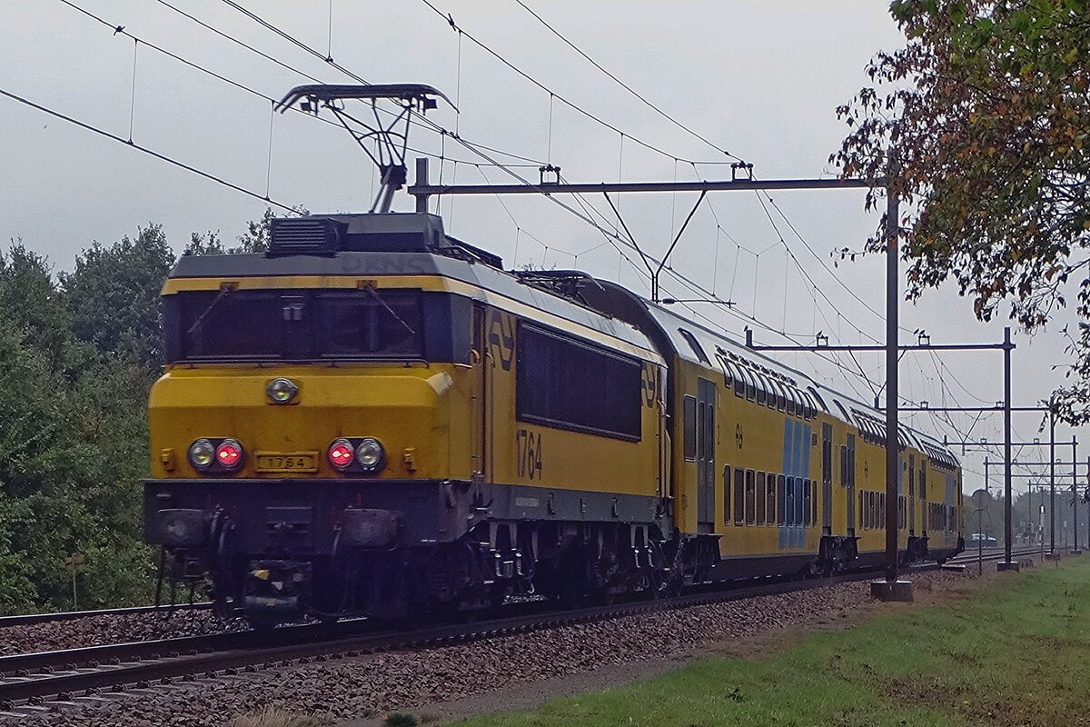 On a rainy 4 October 2019 NS 1q764 pushes a DD-AR stopping train through Wijchen toward Nijmegen.