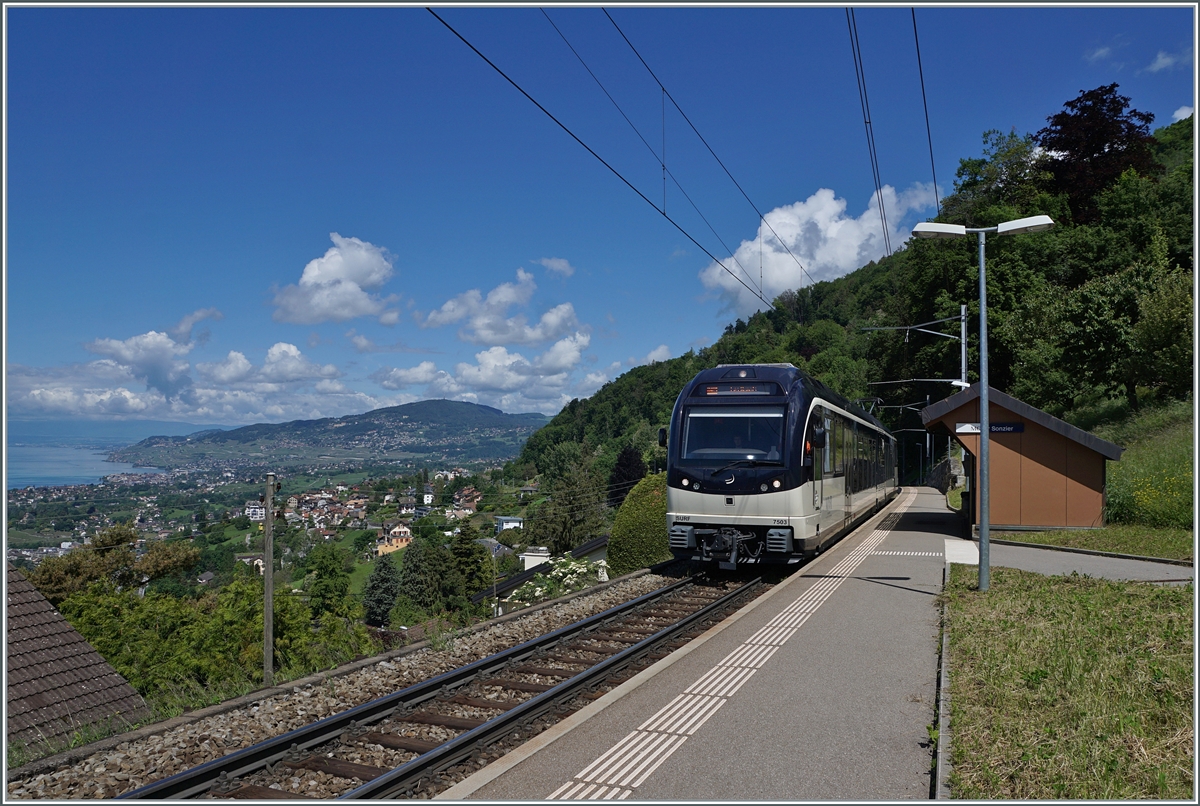 Picture with a view: While the CEV MVR ABeh 2/6 7503  Blonay-Chamby  reaches the Sonzier station as a regional train from Montreux to Les Avants, the view on the left glides far over the Riviera Vaudoise and the Lavaux. 

May 28, 2024