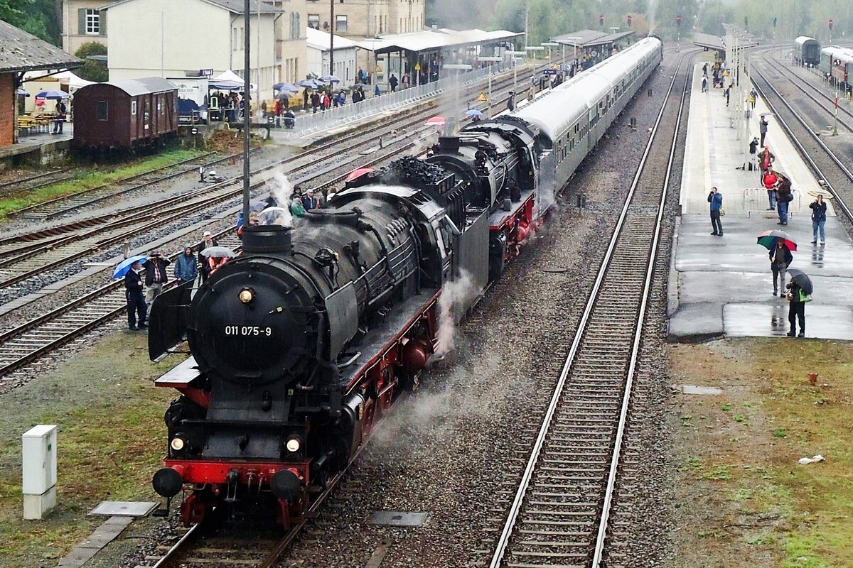 SSN's 011 075 was guest at the DDM in Neuenmarkt-Wirsberg during the weekend on 20/21 September 2014. Here she catches the rain at the station of Neuenmarkt-Wirsberg with one of the many steam shuttles across the Schiefe Ebene on 21 September 2014.