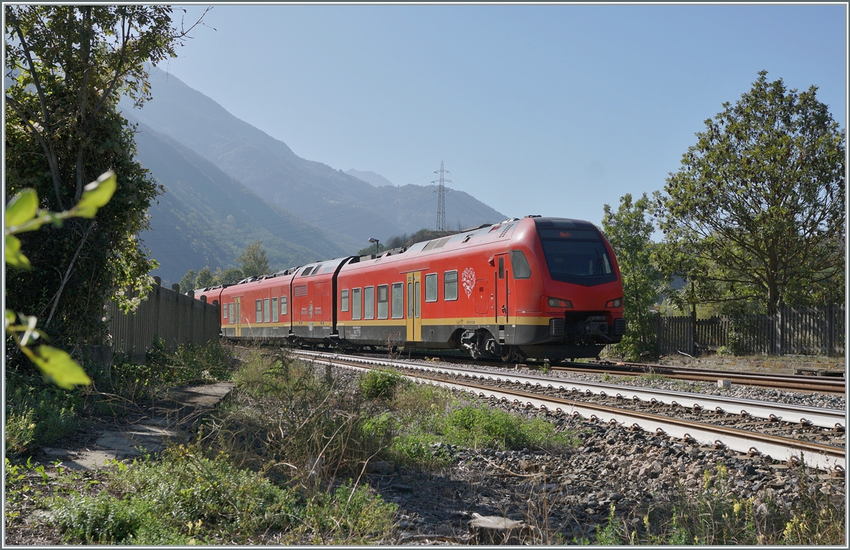 The bi-modular FS Trenitalia BUM BTR 813.001 from Torino to Aosta leaves the Chatillon Saint Vincent train station in the backlight. October 11, 2023