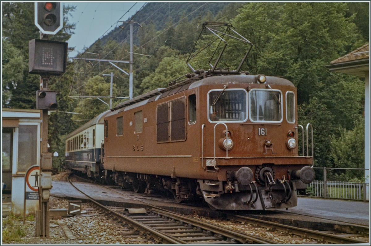 The BLS Re 4/4 161 (Ae 4/4 II till 1969) with his EC  Thunersee  is arriving at Interlaken Ost.

analog picture / summer 1987