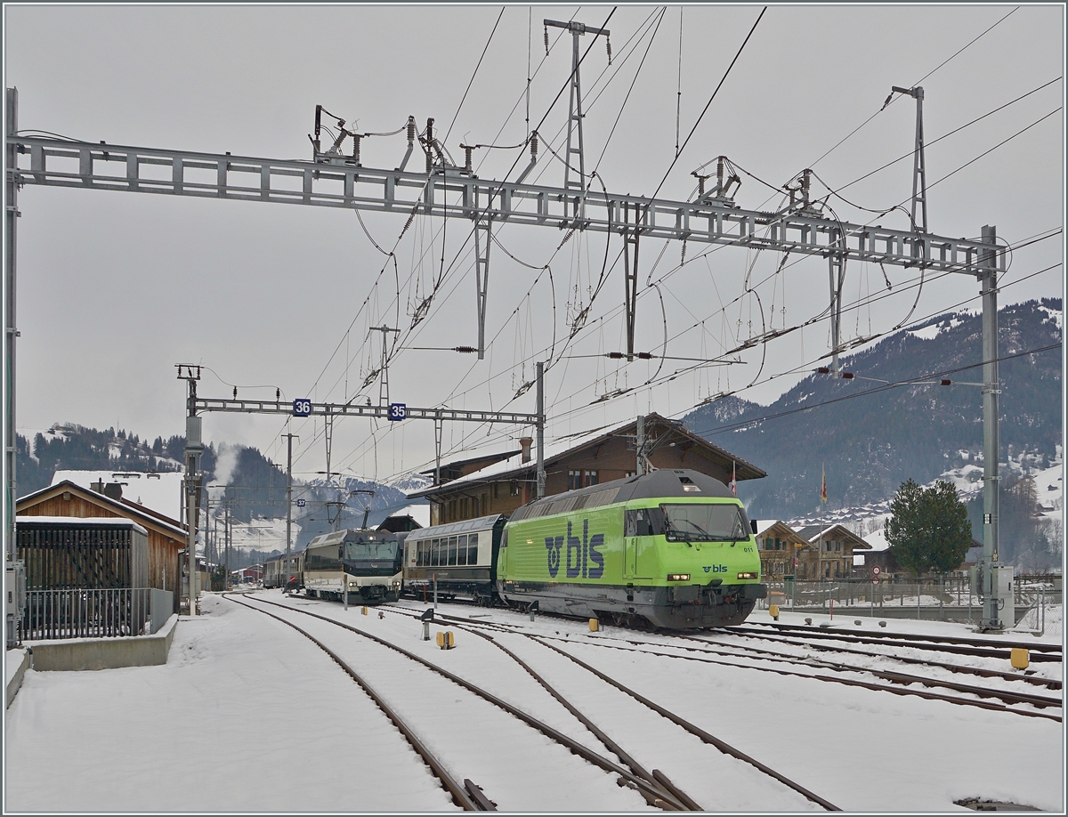 The BLS Re 465 011 is arriving with his GoldenPass Express GPX 4065 from Interlaken Ost to Montreux at the Station of Zweisimmen. In the background is waiting the MOB Ge 4/4 8002. 

15.12.2022