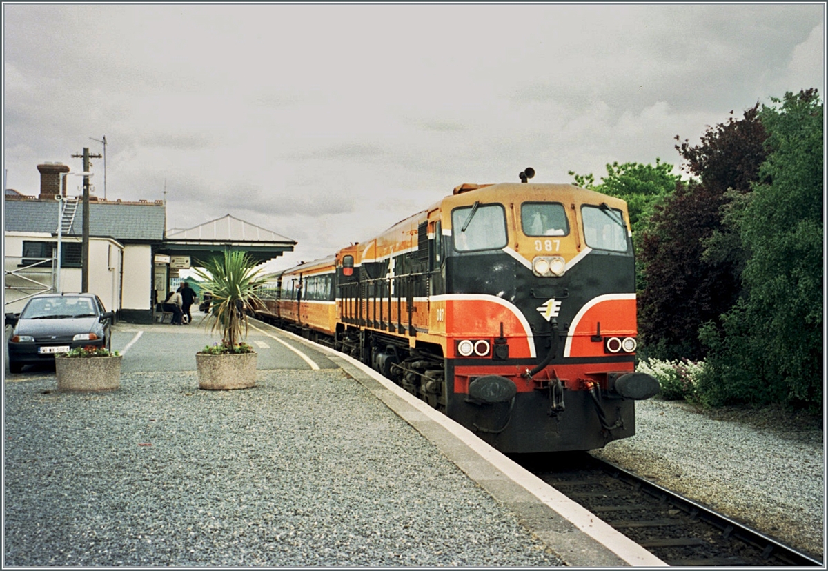 The CIE (Iarnród Éireann) diesel locomotive CC 087 with the IC from Dublin to Rosslare has reached Wexfort Station / Stásiún Loch Gorman. I got out quickly and was able to take this picture, which was of course a win given the (at the time) rather thin timetable of only four pairs of trains.

Analog image from June 2001