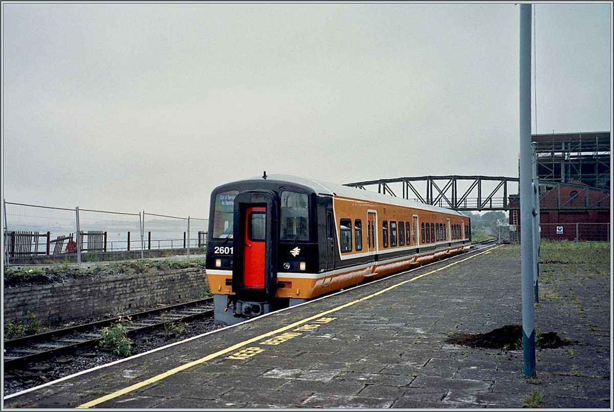 The IR CIE diesel railcar 2601 is in Cobh and is waiting for the return journey to Cork / Corcaih. The sea can be seen to some extent on the left of the picture. Today Cobh is a small port town, but is THE port of emigration in Ireland, associated with all the sorrow and song that such a farewell brings with it. Cobh, which used to be called Queenstown, is also known as the last port of embarkation for the Titanic before the journey across the ocean began. An analogue picture from June 2021