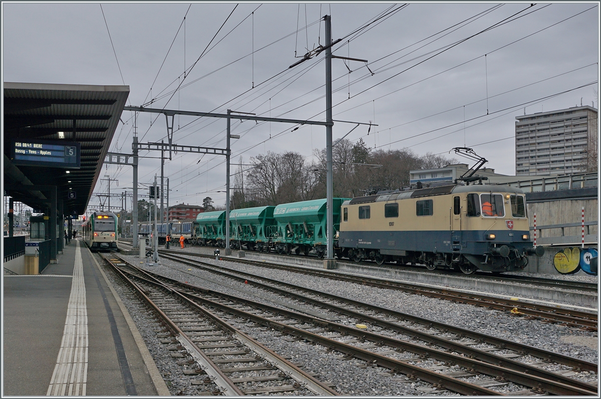 The  IRSI Rheingold Re 4/4 II 11387 (Re 421 387) has arrived in Morges with its gravel train from Gland and is now pushing it over the roller trestle system. March 4, 2024