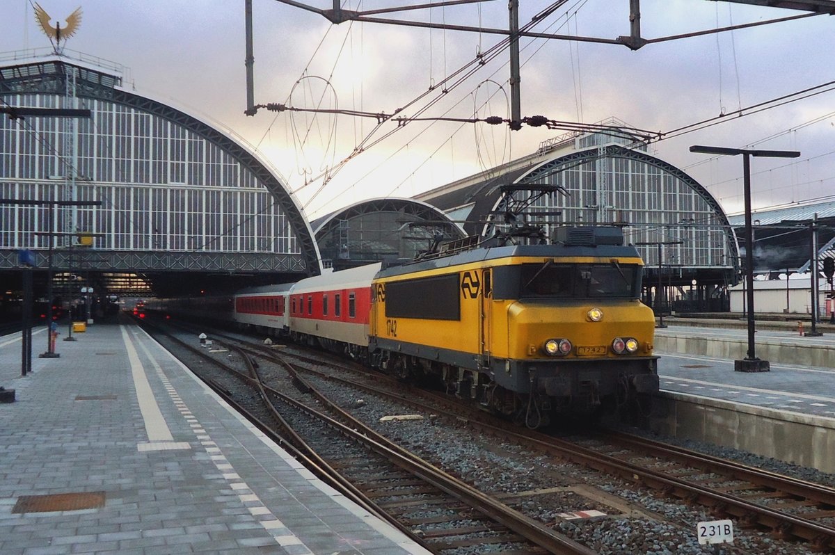 The Sun begins to set over Amsterdam Centraal while NS 1742 hauls a CNL out of the station on 30 March 2013.