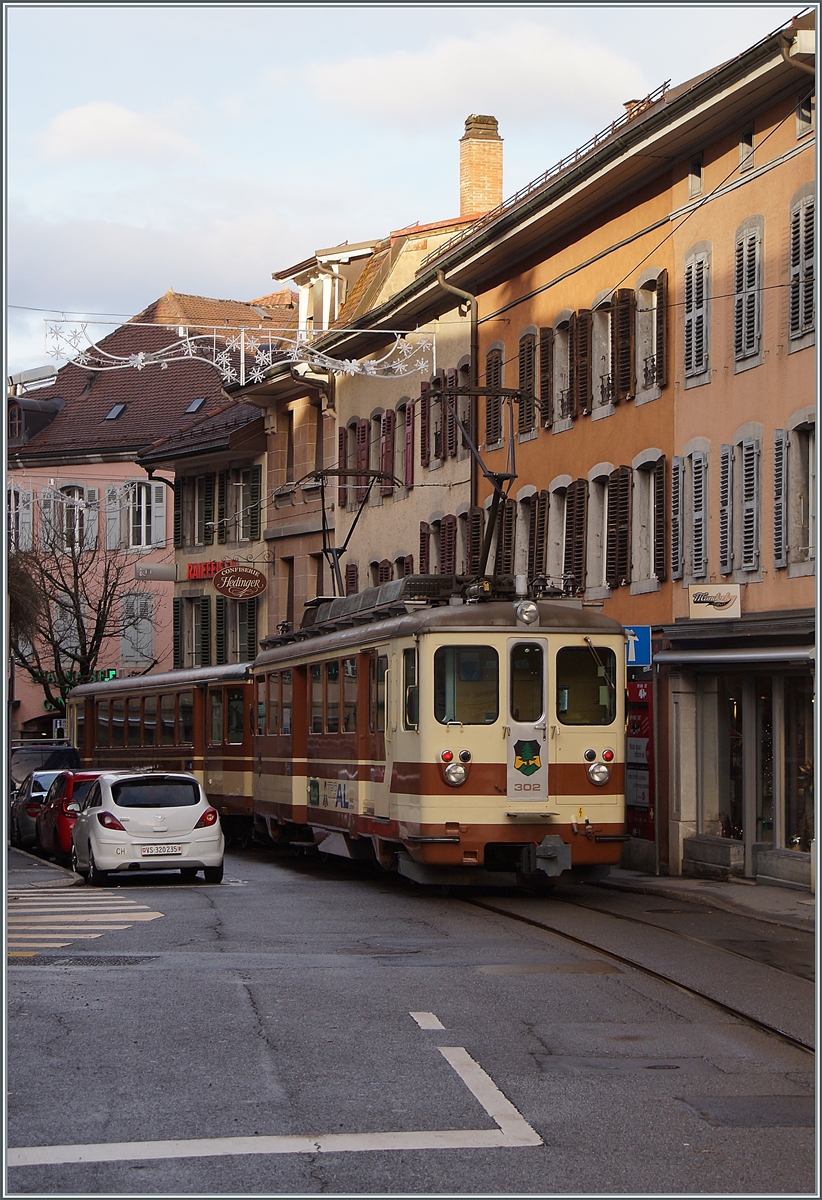 The TPC A-L BDeh 4/4 302 and his Bt 351 on the way to the Aigle Station in the streets of Aigle. 

05.12.2021