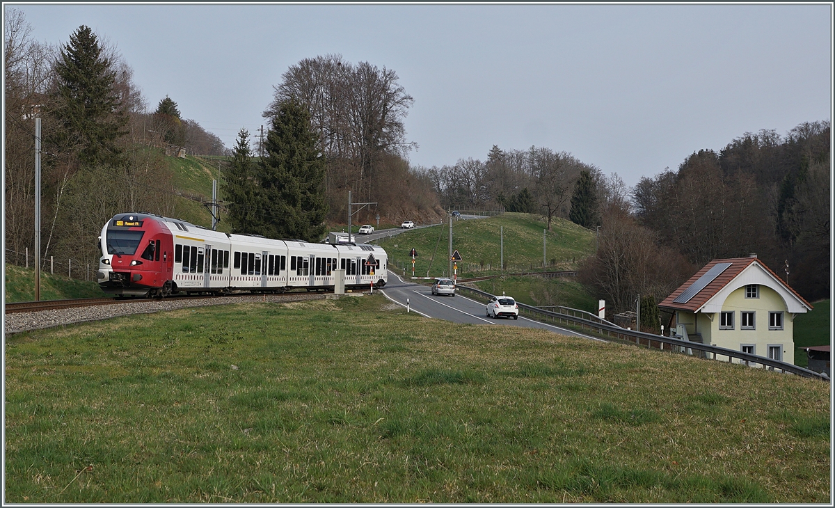 The TPF RABe 527 197 on the way to Fribourg by Pensier. 

29.03.2022