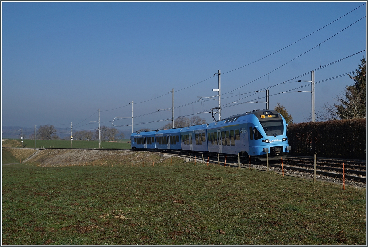 The TPF RABe 527 198 on the way to Bulle by Vuisternens-devant-Romont. 

1. März 2021