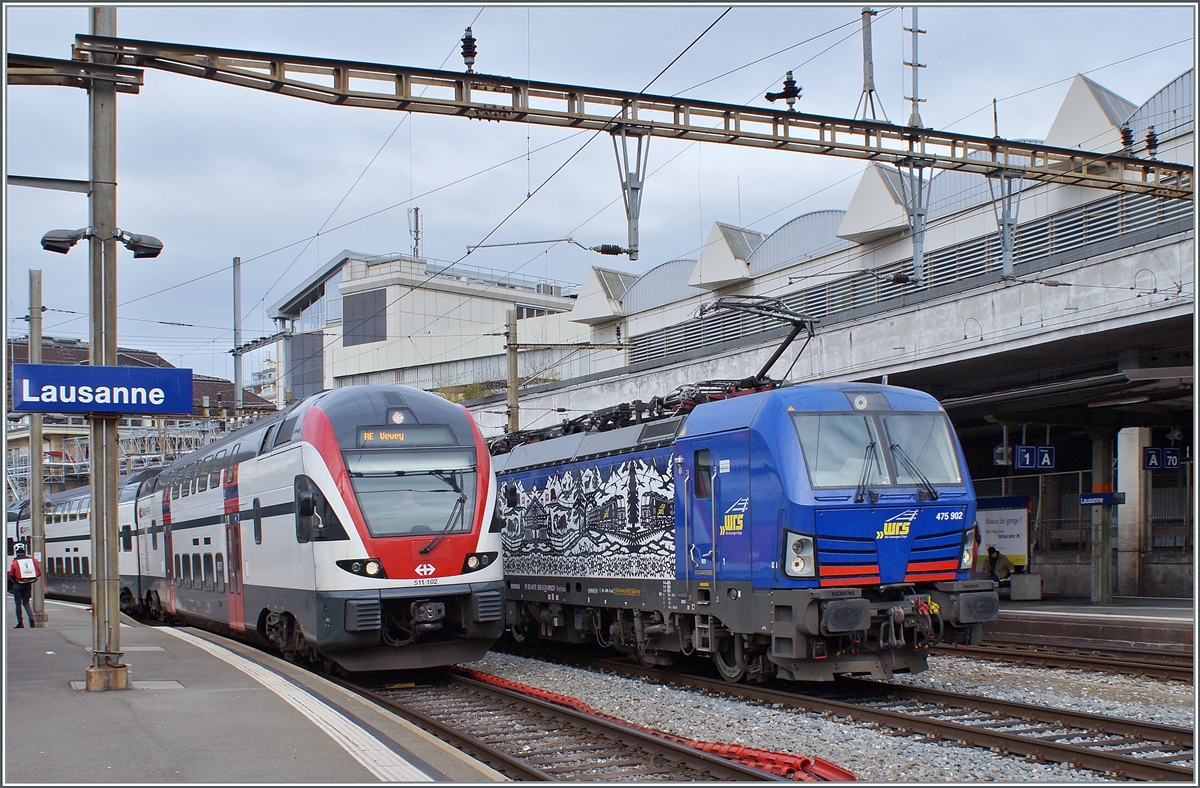 The WRS Vectron Re 475 902 (91 85 4475 902-3 CH-WRSCH) with a Cargo Service and the SBB RABe 511 102 on the way to Vevey in Lausanne. 

17.02.2023