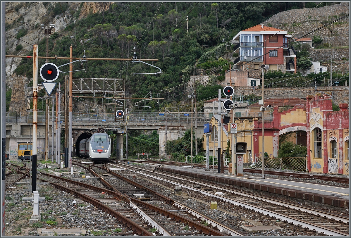 When one of the most beautiful sections of the Genova - Ventimiglia route near Cervia was replaced by a tunnel variant a few years ago, numerous photographers arrived in advance.
The Genova - Savona route opened in 1868. The Savona Ventimiglia continuation, which went into operation in 1972, led through difficult topography in many places and was largely routed along the sea and through the towns.
The route was initially electrified with three-phase current, later planned as V 25,000/50 Hz, and then finally in 1964/1967 it was supplied with FS DC 3000.
But by this time the single-track route along the sea was no longer sufficient to cope with the increasing traffic, so the first new routes were built in the Genova area at the end of the 1960s. In 1977, the Varazzo - Finale Ligure section was the first longer new construction section. Over time, others followed further west, but in Finale Ligure the first new section now meets the last original section. This is also the motif of the pictures from Finalie Ligure, here the FS Trenitalia IC 631 leaves the single-lane, 1136 meter long  Galleria Caprazoppa .
Photo location: end of platform)
September 16, 2023