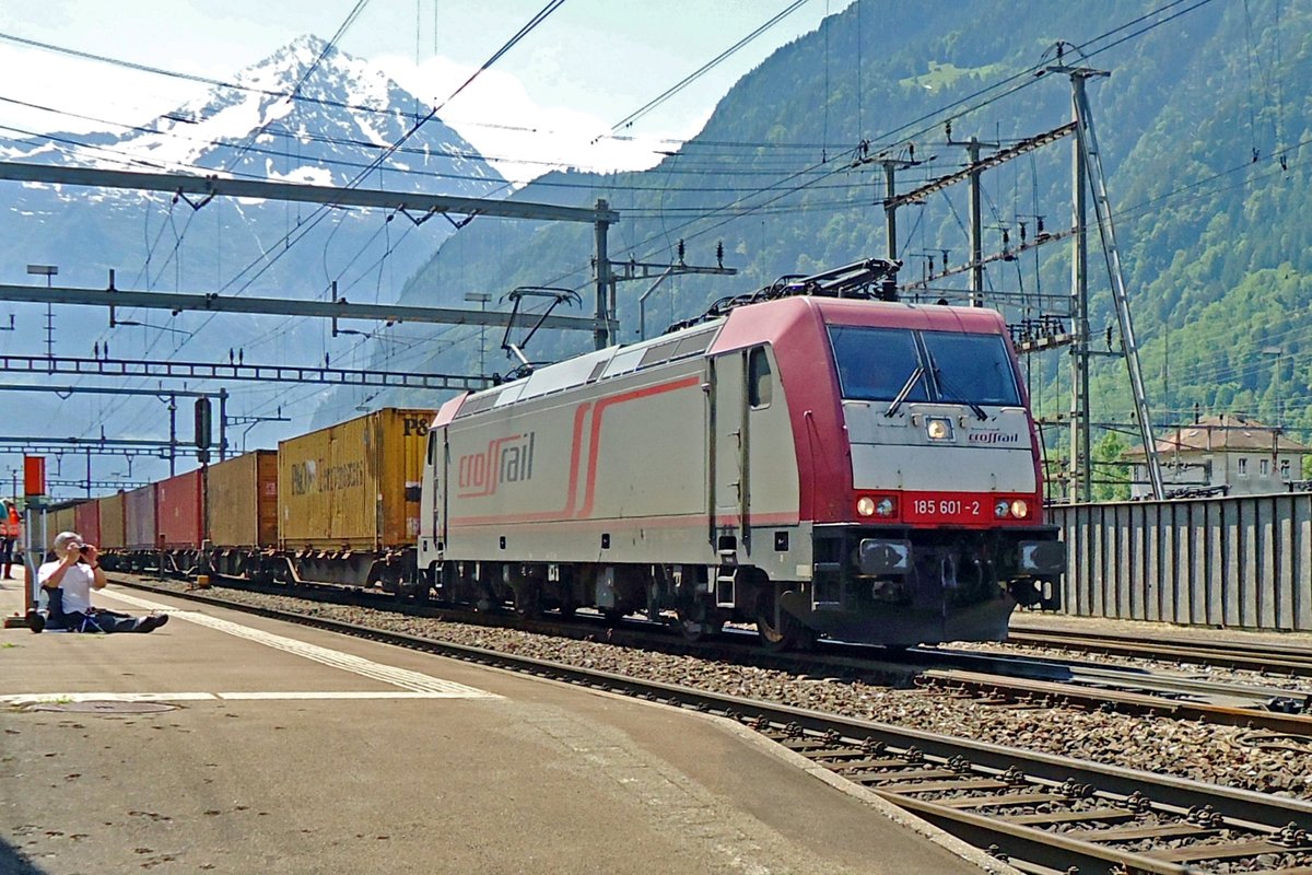XR 185 601 hauls a container train through Erstfeld on 6 June 2015. The filmer in the background seems to be to lazy to stand on his feet while practising his hobby! 
