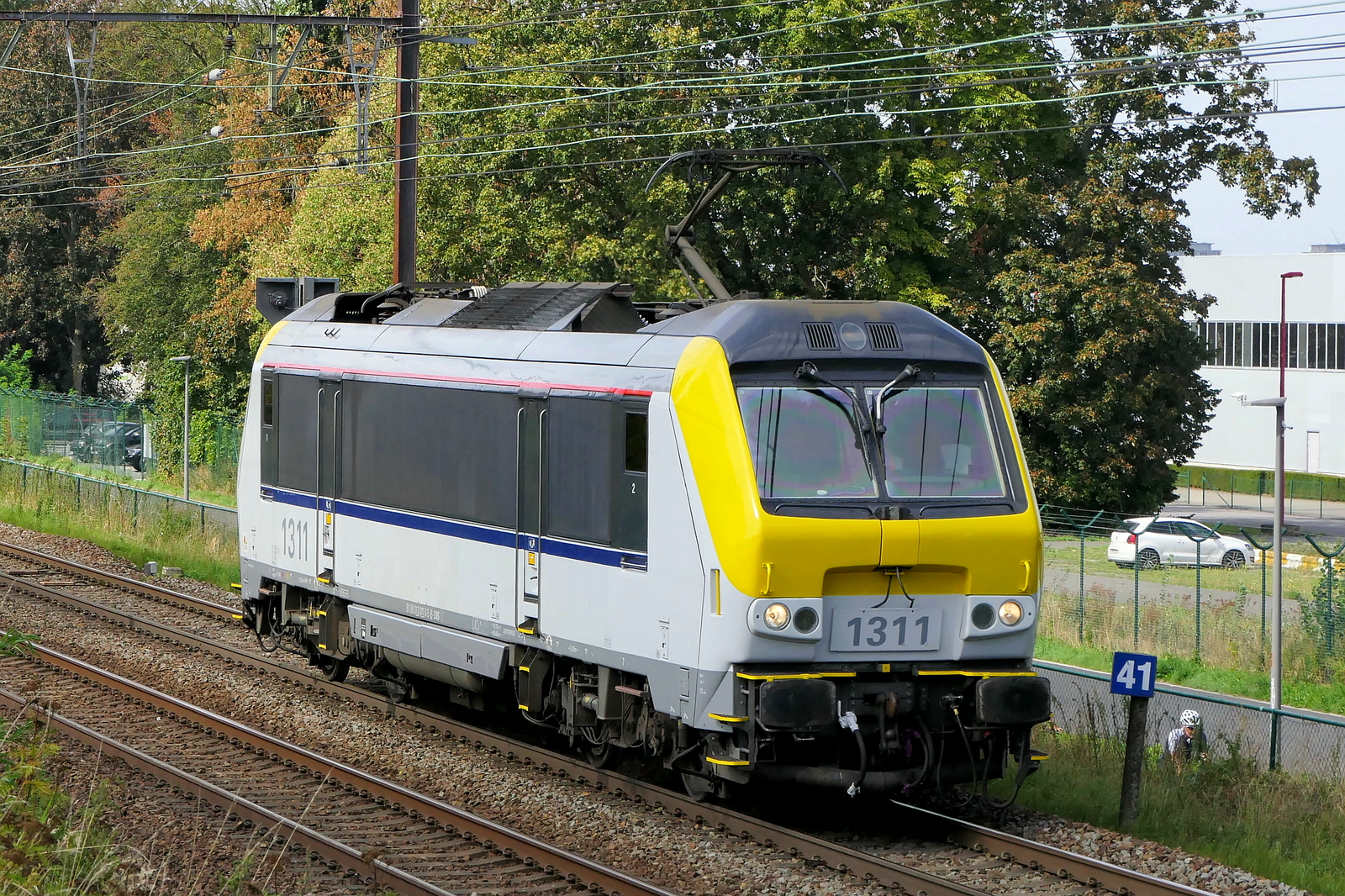 The Lineas 1311 on route out of the port of Antwerp. Bombardier Brugge NMBS serie 13 build in 1999 with construction N� 1326. NMBS Class 13: between 1997 and 2001  80 of these locomotives were build by Bombardier Brugge. Concept and parts from Alstom Belfort. Original NMBS numbers: 1301 to 1360, CFL numbers: 3001 to 3020. Max speed: 200km/h. Power: 5200kW. Power supply: 3000V and 25kV.  Numbers 1301 to 1345 are in service at Lineas, numbers 1346 to 1360 are in service at the NMBS. Line 27A at Antwerp Airport. 07-09-2026