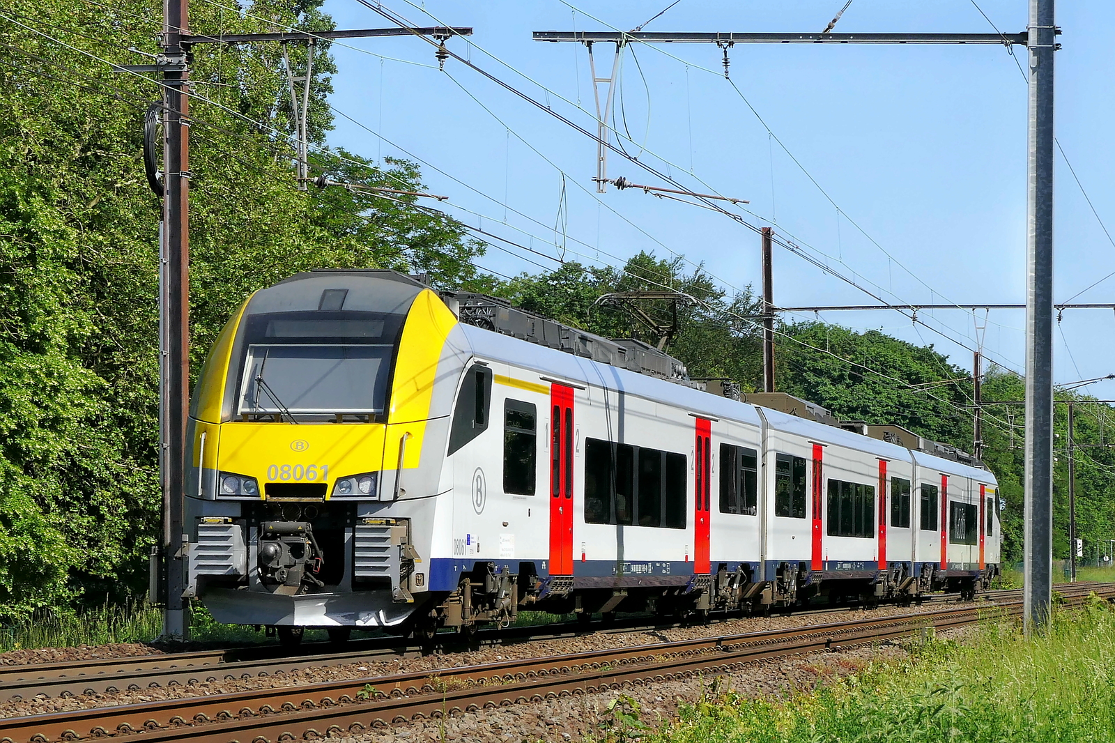 The NMBS 08061 on route from Antwerpen-Berchem to Lier station.  Siemens Desiro ML build in 2013. NMBS Class MR08 (EMU08) Desiro ML : Between 2011 and 2016  305 of these EMU (Electric Multi Unit) were build. The first 105 by Siemens, the last 200 by Bombardier. Numbers: 08001 to 08210 and 08501 to 08595. Number of carriages: 3. Length: 79,90m. Number of seats: 280. Max speed: 160km/h. Power supply: n� 08001 to 08210: 3000V , n� 08501 to 8595: 3000V en 25kV. Line 27A at Antwerp Airport. 28-05-2026
