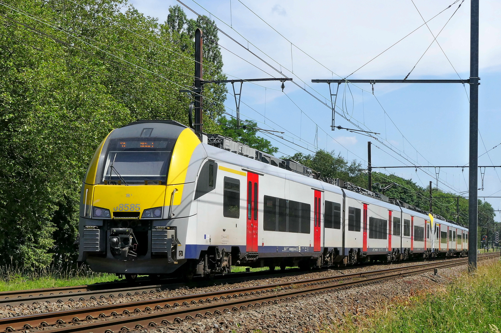 The NMBS 08585 together with the 08005 on route from Antwerpen-Berchem to Lier station as IC with destination Hamont. Siemens Desiro ML build in 2015. NMBS Class MR08 (EMU08) Desiro ML : Between 2011 and 2016  305 of these EMU (Electric Multi Unit) were build. The first 105 by Siemens, the last 200 by Bombardier. Numbers: 08001 to 08210 and 08501 to 08595. Number of carriages: 3. Length: 79,90m. Number of seats: 280. Max speed: 160km/h. Power supply: n� 08001 to 08210: 3000V , n� 08501 to 8595: 3000V en 25kV. Line 27A at Antwerp Airport. 18-06-2026
