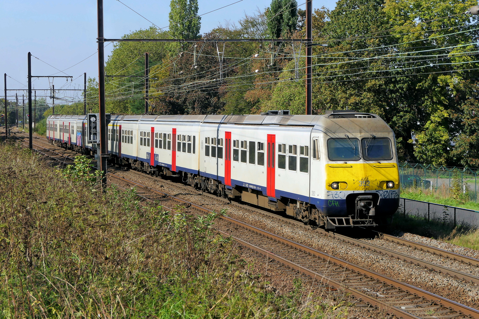 The NMBS 392 and an other MS80 EMU on route from Antwerpen-Berchem to Lier station. BN Brugge build in 1983, modernized in 2017. NMBS Class MS80-82 and 83 (MR80 / EMU80) : Between 1979 and 1985 140 of these EMU (Electric Multi Unit) were build by BN Brugge. Numbers: 301 to 440. Number of carriages, original 2 now after modernizing: 3. Length (3 carriages) 75,80m. Number of seats (3 carriages) 248. Max speed: 160km/h. Power supply: 3000V and 1500V. Line 27A at Antwerp Airport. 29-09-2026
