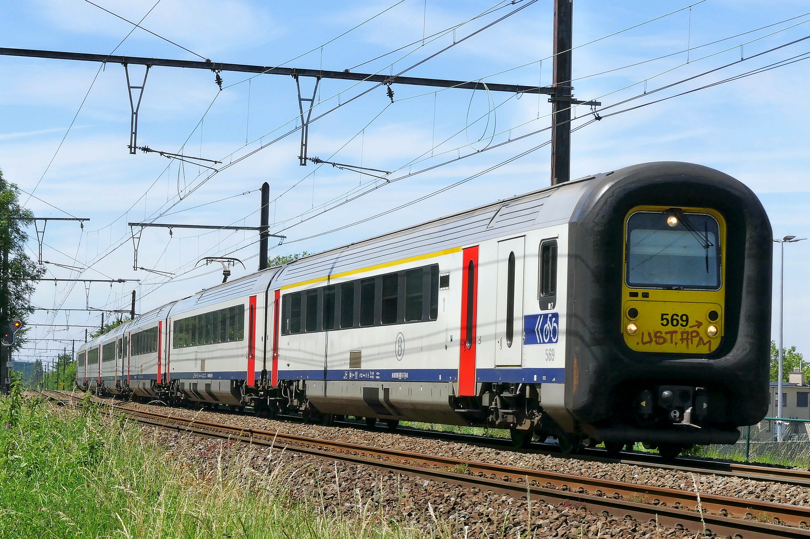 The NMBS 569 on route from Antwerpen-Berchem to Lier station. Bombardier MS96 build in 2000. NMBS Class MS96 (MR96/EMU96) : Between 1996 and 2000 120 of these EMU (Electric Multi Unit) where build by Bombardier Brugge. Numbers: 441 to 490 and 501 to 570. Number of Carriages: 3. Length: 79,20m Number of seats: 213. Max speed: 160km/h. Power supply: numbers 441 to 490: 3000V and 25kV , numbers 501 to 570: 3000V. Nickname: Danish Nose.  Line 27A at Antwerp Airport. 18-06-2026