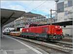 The SBB Aem 940 025 (Aem 91 85 4 940 025-0 CH-SBB I) awaits its onward journey in Lausanne with the mighty Rhomberg Sersa KRC 1200 crane truck (CH RSRM99 85 9219 102-2) and two escort cars (33 85 4505 172-8 TEN-CH WASCO Sgmmns and 33 85 4505 173-6 TE ...