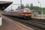 On 30 May 2013, NMBS 813 leaves Antwerpen-Noorderdokken in the rain.