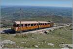 One of the six Chemin de Fer de La Rhune He 2/2 three-phase locomotives is almost at the destination of the journey with its train: at the La Rhune summit station at 905 meters above sea level.