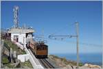 La cima: Una de las locomotoras de corriente alterna trifásica  He 2/2  del Chemin de Fer de la Rhune parte con su tren desde la estación de la cima La Rhune, situada en el País Vasco