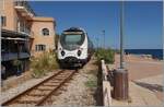 Der  U Caminu di Ferru di a Corsica AMG 813/814 ist als Train de Grandes lignes 101/151 von Bastia nach Calvi unterwegs und f�hrt zwischen Altstadt und Strand dem Bahnhof von Lisula Rossa / Ile Rouse