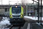 Il 19 febbraio 2026 il sole inizia a tramontare mentre CapTrain 159 102 traina un convoglio di cereali attraverso Amburgo Harburg.