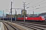 DB electric locomotive 185 248-2, along with another locomotive, is pulling a freight train through the Linz station.