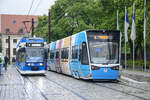 Trams 671 (line 6) and 602 (line 5) belonging to RSAG (Rostocker Straßenbahn AG) pass each other at Neuer Markt in Rostock.  Date: 8th June 2025.