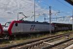 Locomotive E 412 005 from MERC.ITALIA RAIL pulls a goods train past Verona Porta Nuovo station with another locomotive.