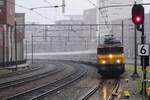 Under the pouring rain, NS 1746 hauls an IC-Berlijn into Amersfoort on 3 February 2022.