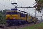 On a rainy 4 October 2019 NS 1q764 pushes a DD-AR stopping train through Wijchen toward Nijmegen.