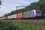 Akiem 186 359 hauls a container train through Tilburg Oude Warande on 4 August 2019.
