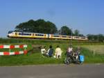 Sprinter as sprintertrain to Amsterdam CS near Baarn watched by local people taking a break from working on their vegetebal garden. 26.07.2012 (picture taken and published with their permission)